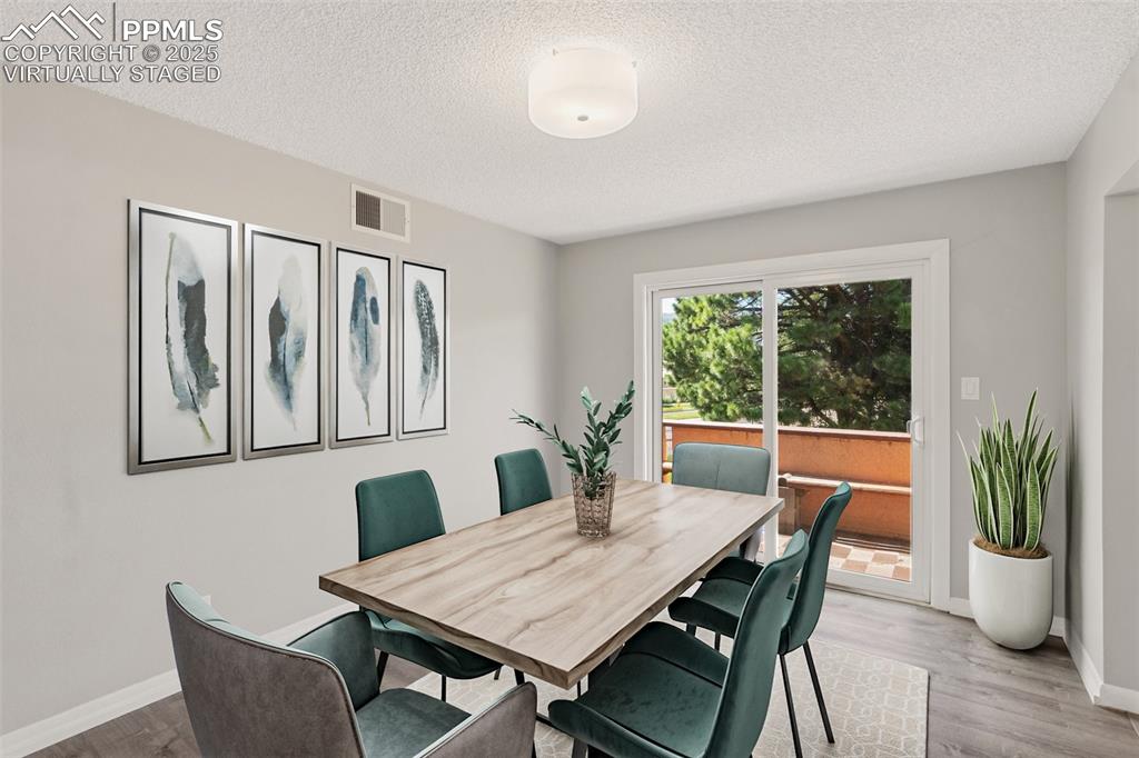 Image 12 of 48: Virtually Staged - Dining room featuring light wood-type flooring and a tex