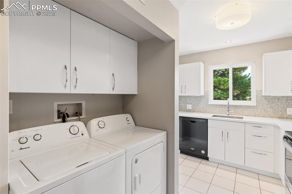 Image 19 of 48: Washroom featuring washer and clothes dryer and light tile patterned floors