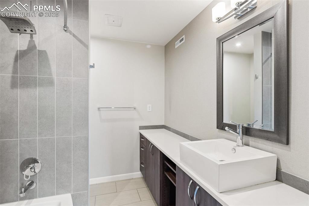 Image 20 of 48: Master bath with vanity, tile patterned flooring, and washtub / shower comb