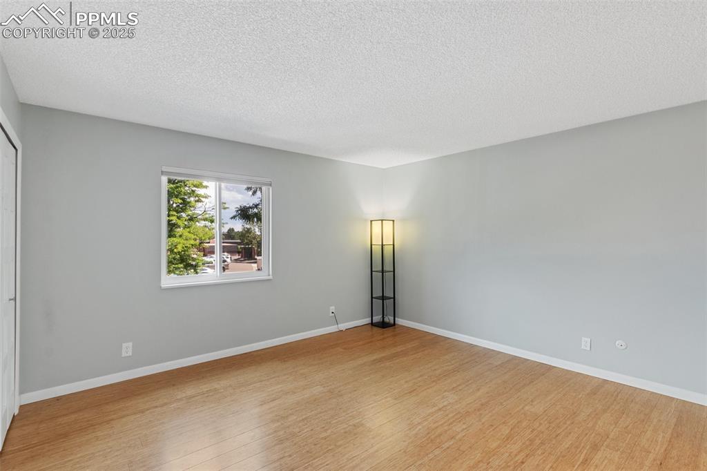 Image 22 of 48: Master Bed featuring light wood-type flooring and a textured ceiling