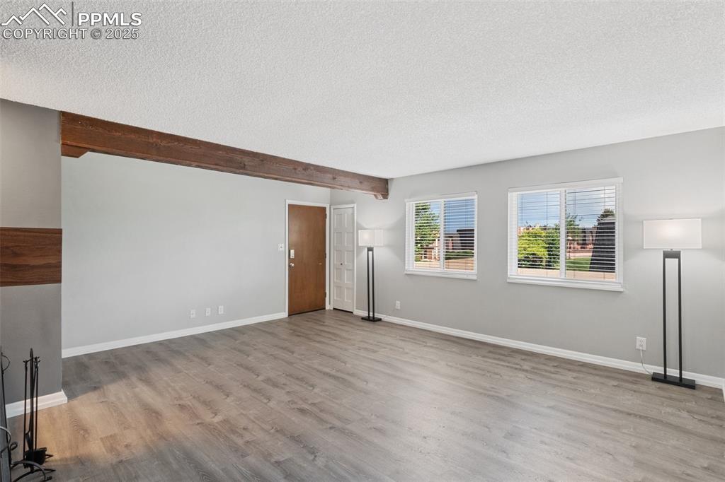 Image 37 of 48: Unfurnished living room featuring a textured ceiling, wood finished floors,