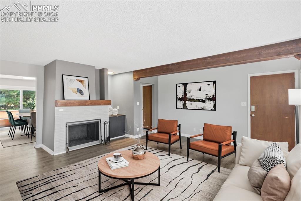 Image 7 of 48: Virtually Staged - Living area with wood finished floors, a textured ceilin