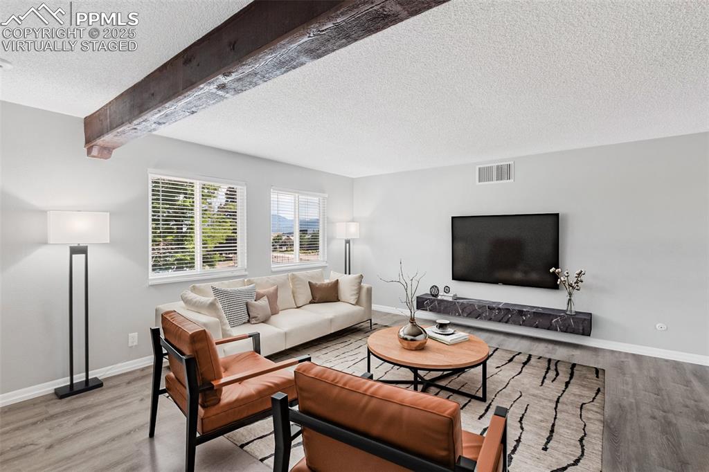 Image 8 of 48: Virtually Staged - Living room featuring a textured ceiling, light wood fin
