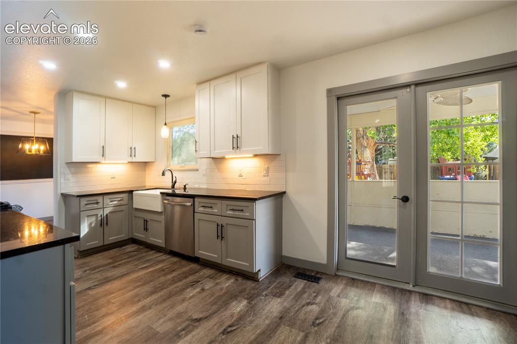 Image 12 of 33: Kitchen featuring wood-finish flooring, two-tone cabinetry with under-cabin