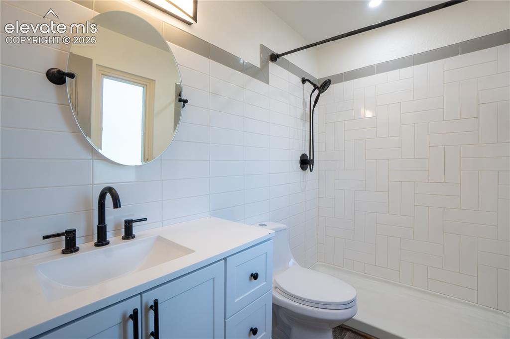 Image 15 of 33: Bathroom featuring a light-toned vanity with a built-in sink, matte black f