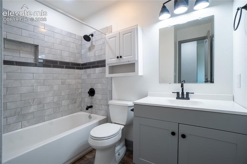 Image 18 of 33: Bathroom featuring a white bathtub with light gray subway tile surround and