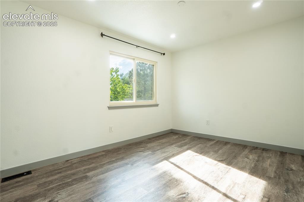 Image 19 of 33: Room featuring a single window, recessed ceiling lighting, wood-finish floo