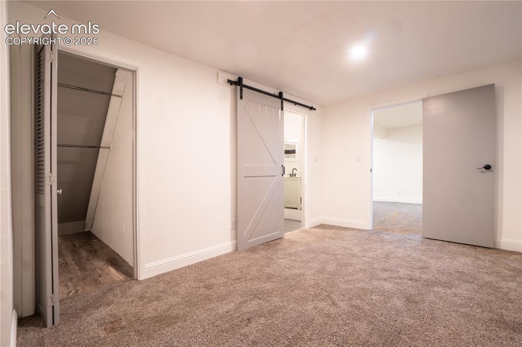 Image 24 of 33: Neutral-toned carpet flooring with white baseboards