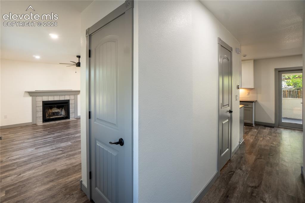 Image 5 of 33: Hallway featuring wood-finish flooring, light grey doors with black hardwar