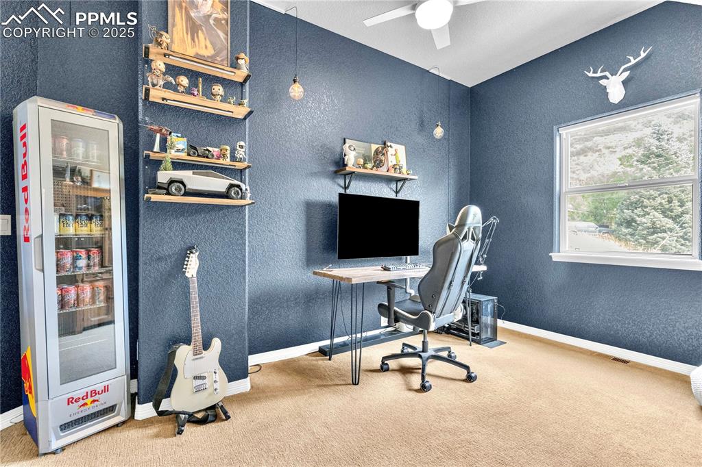Image 13 of 29: Carpeted office featuring a textured wall and ceiling fan