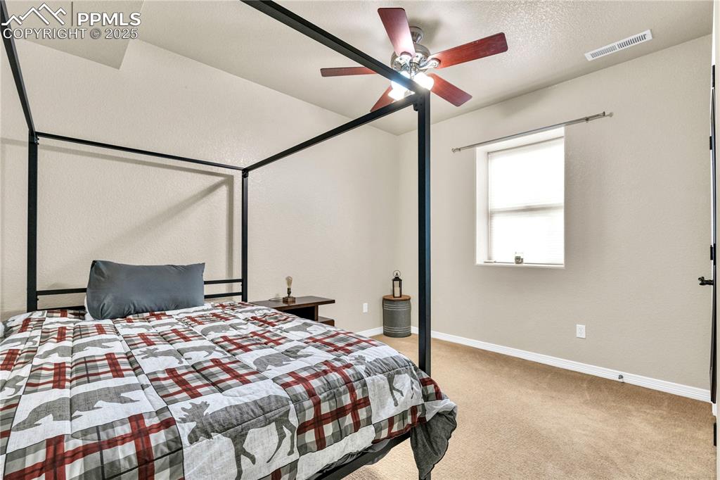 Image 15 of 29: Carpeted bedroom featuring a textured ceiling and ceiling fan