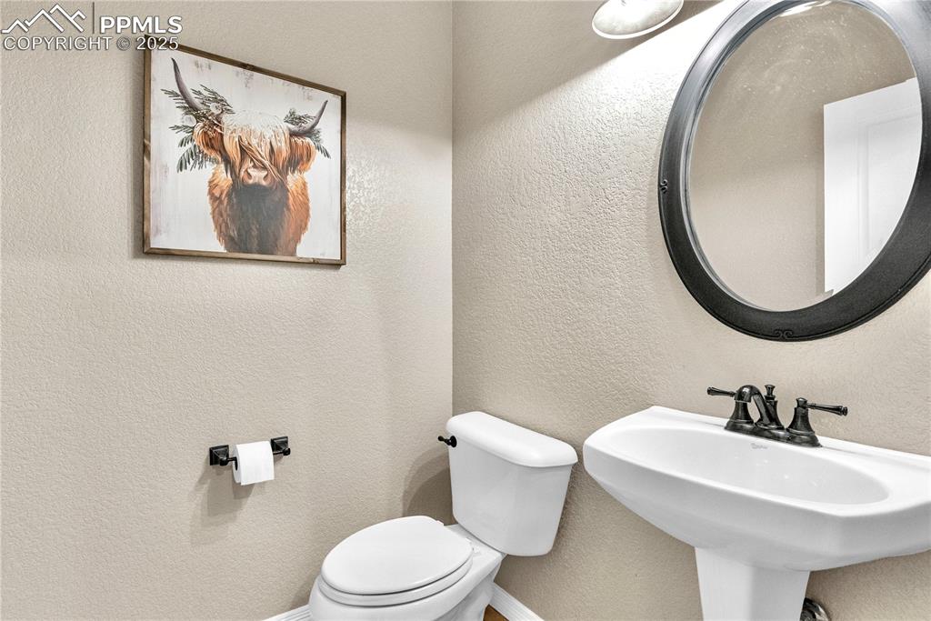 Image 18 of 29: Half bath with toilet and a textured wall