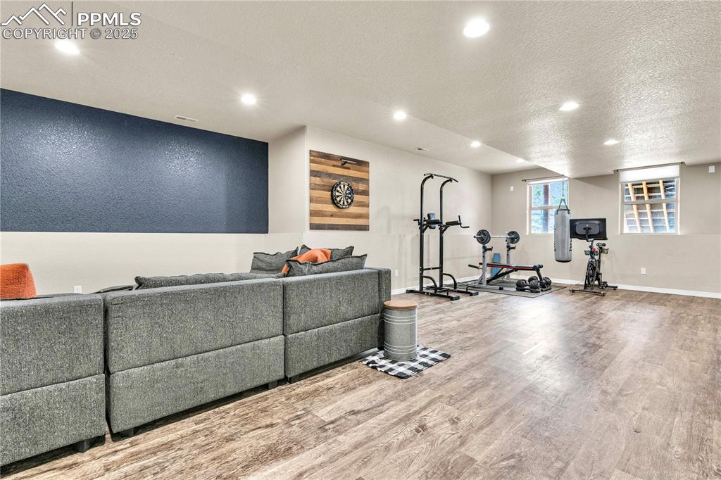 Image 21 of 29: Exercise area featuring a textured ceiling, recessed lighting, and wood fin