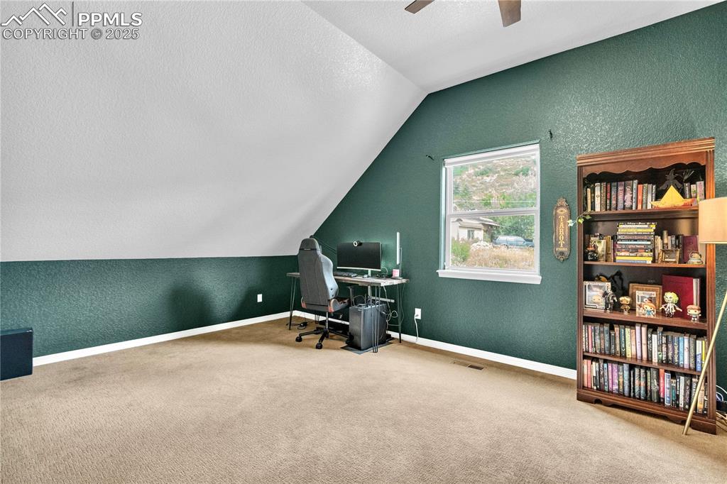 Image 23 of 29: Carpeted office space featuring a textured wall, a textured ceiling, lofted