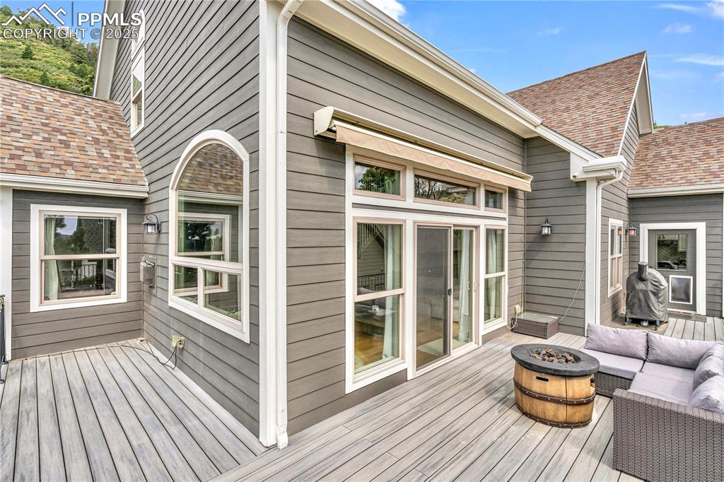 Image 3 of 29: Wooden deck with an outdoor living space with a fire pit and a grill