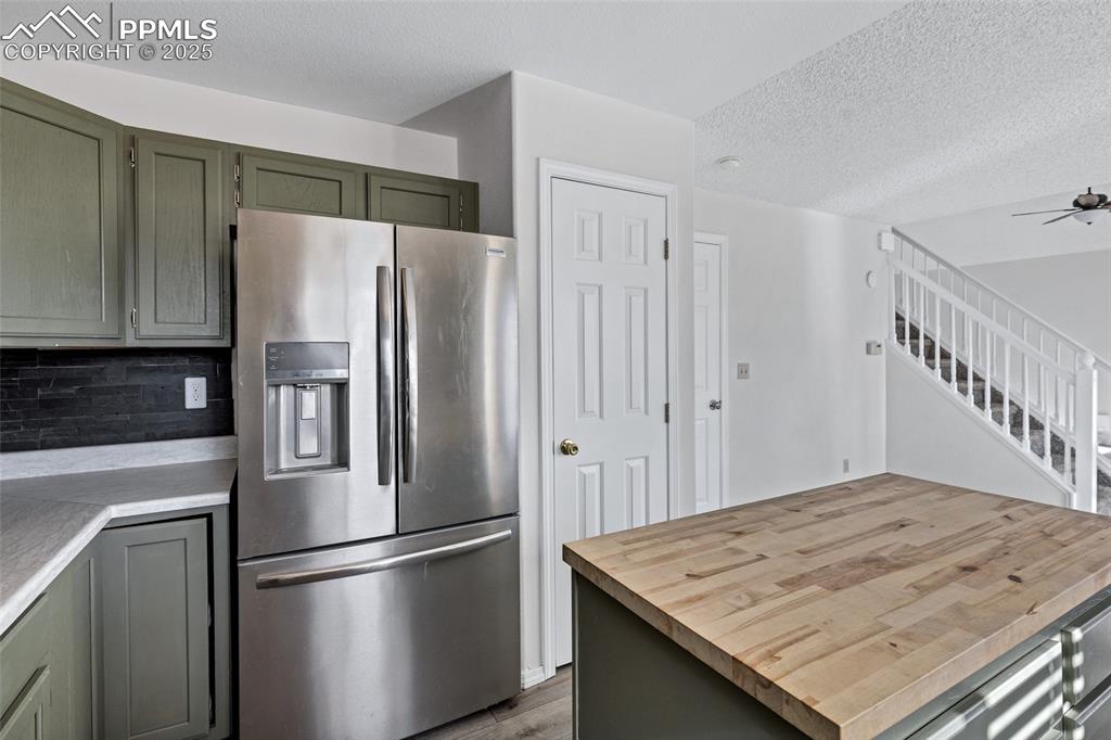 Image 12 of 25: Kitchen featuring stainless steel refrigerator with ice dispenser, butcher 