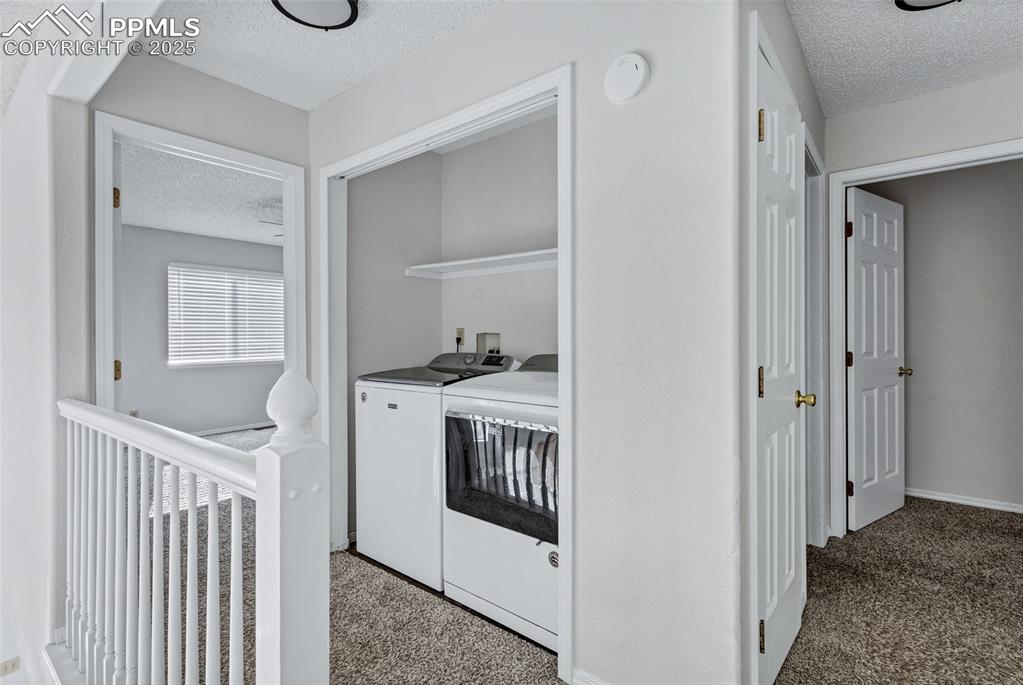 Image 13 of 25: Laundry area featuring a textured ceiling, separate washer and dryer, and c