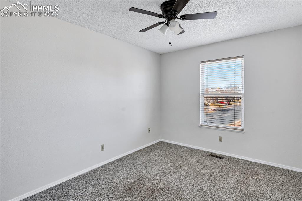 Image 18 of 25: Carpeted spare room featuring a textured ceiling and ceiling fan