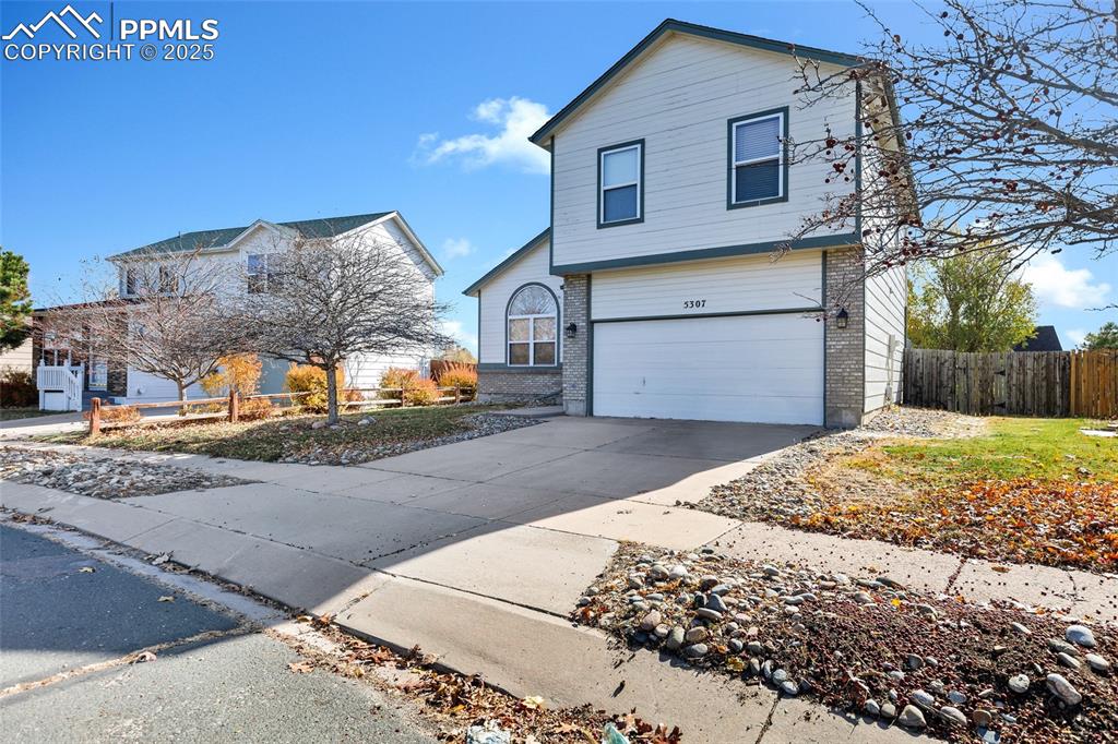 Image 2 of 25: Traditional home with brick siding, concrete driveway, and a garage