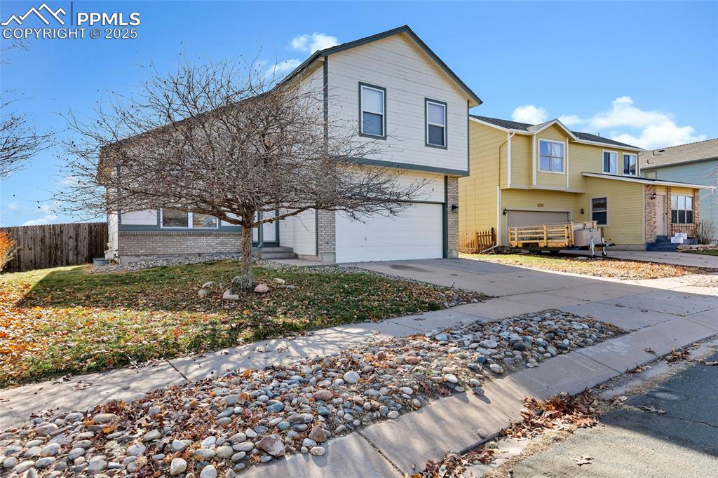 Image 3 of 25: View of front facade featuring brick siding, concrete driveway, and an atta
