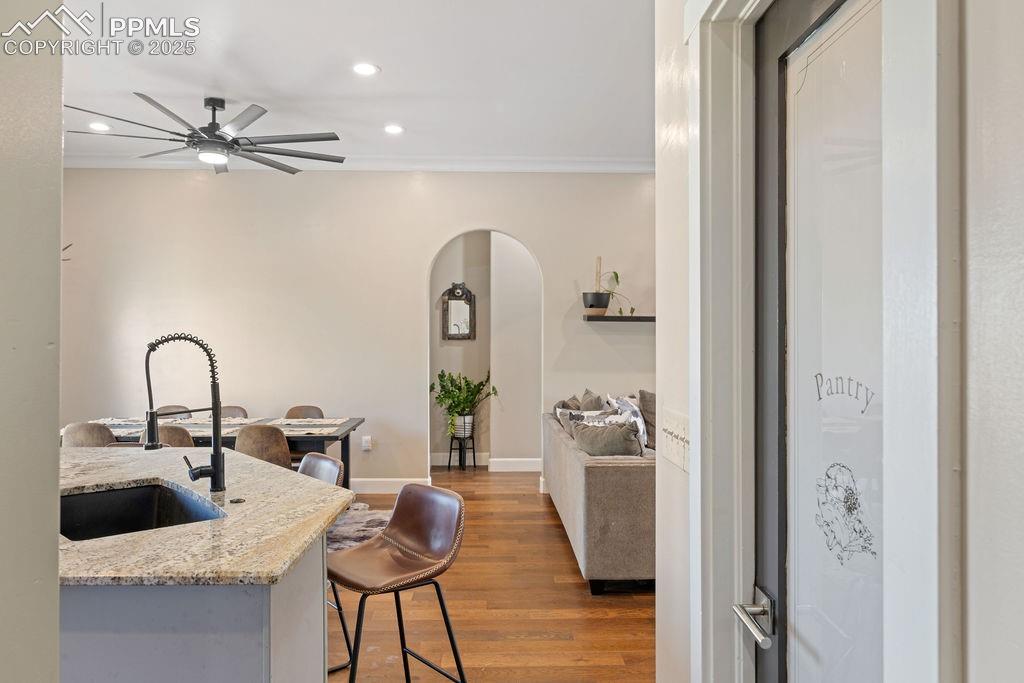 Image 10 of 50: Kitchen with dark wood-style floors, arched walkways, recessed lighting, a
