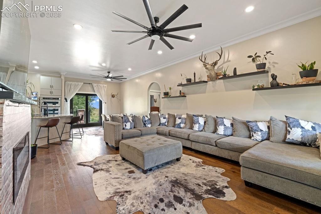 Image 11 of 50: Living room with a glass covered fireplace, ornamental molding, wood-type f