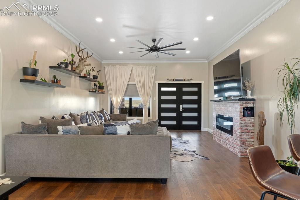 Image 12 of 50: Living room with ornamental molding, recessed lighting, dark wood-type floo