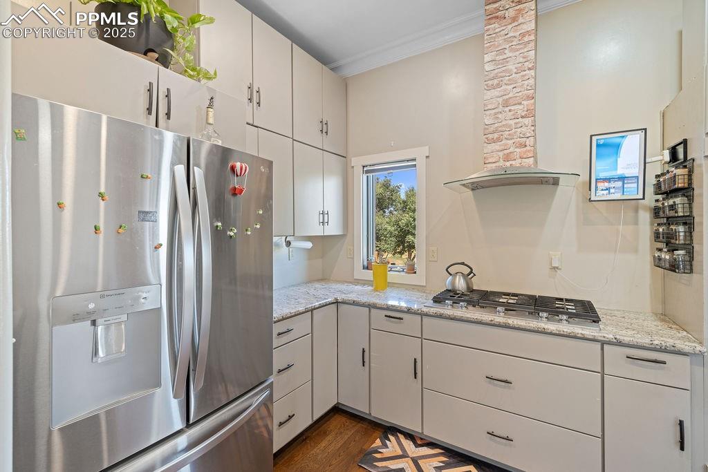 Image 16 of 50: Kitchen with appliances with stainless steel finishes, wall chimney range h