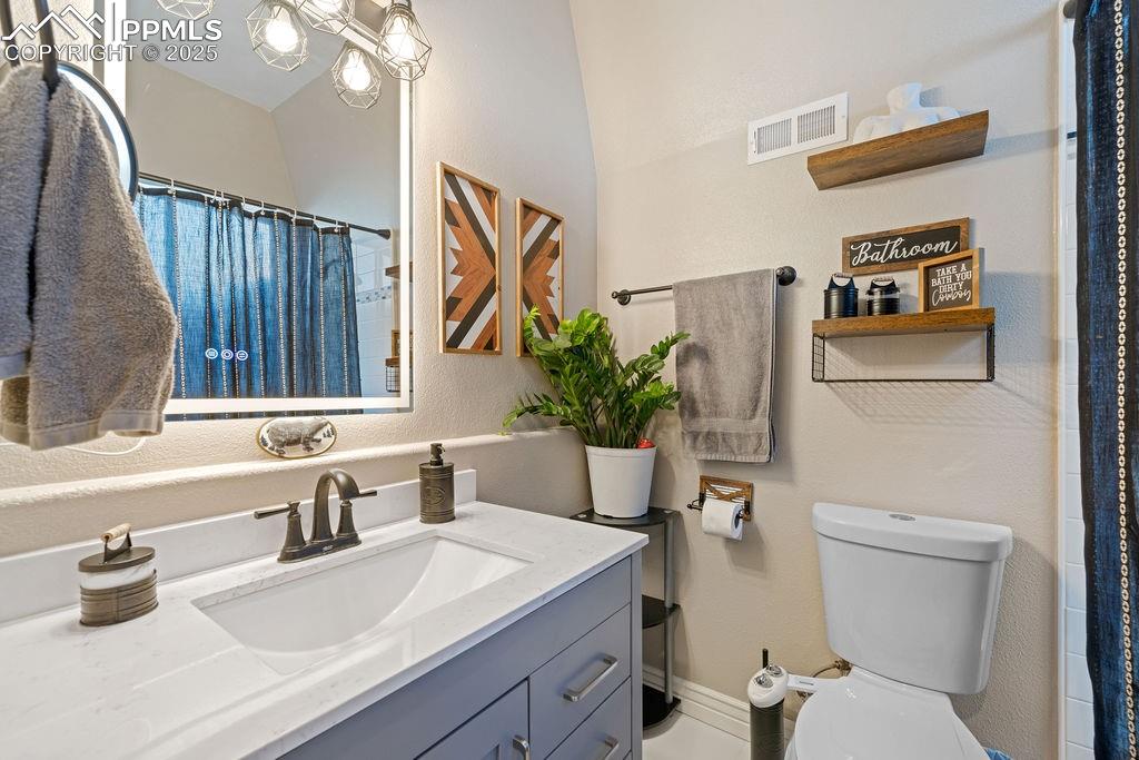 Image 18 of 50: Bathroom featuring a shower with curtain, vanity, and a textured wall