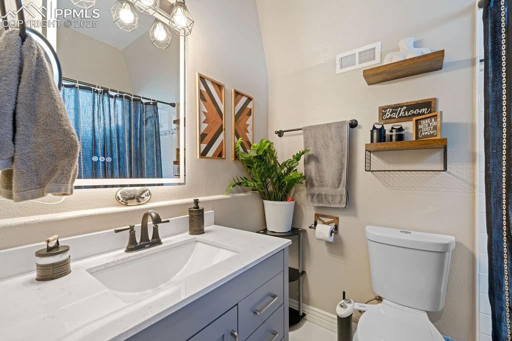 Image 18 of 50: Bathroom featuring a shower with curtain, vanity, and a textured wall