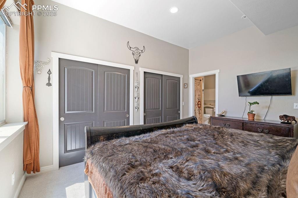 Image 22 of 50: Bedroom featuring multiple closets, light colored carpet, recessed lighting
