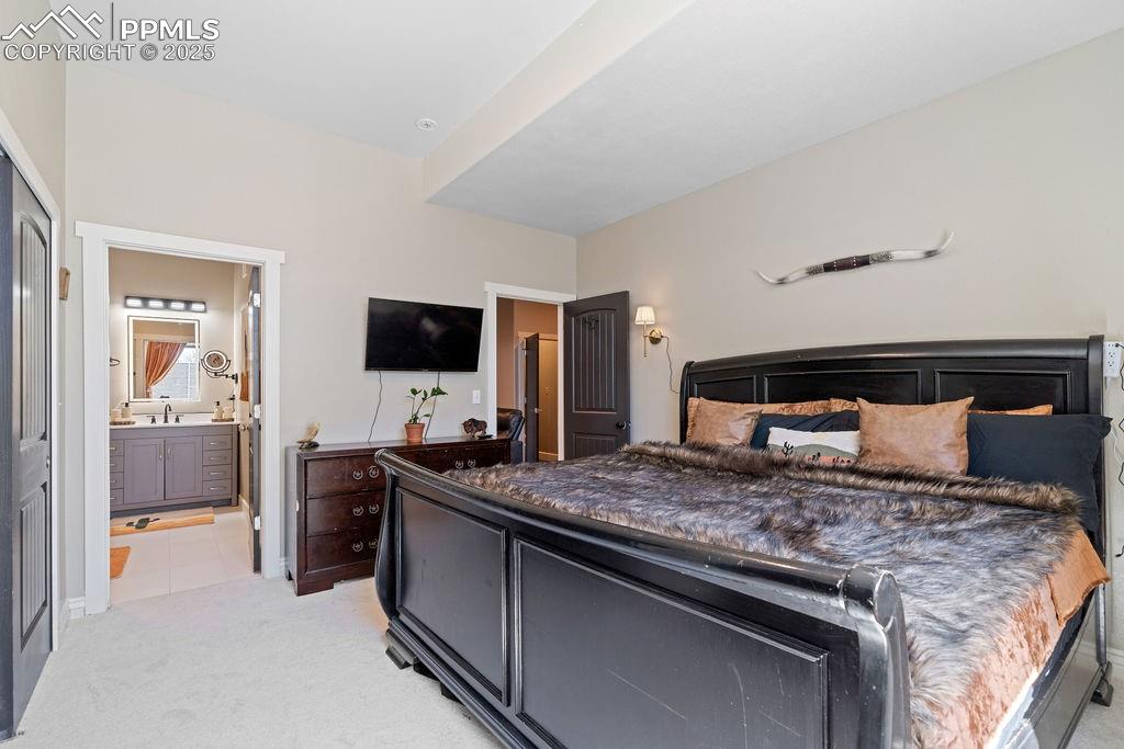 Image 23 of 50: Bedroom with light colored carpet and light tile patterned flooring