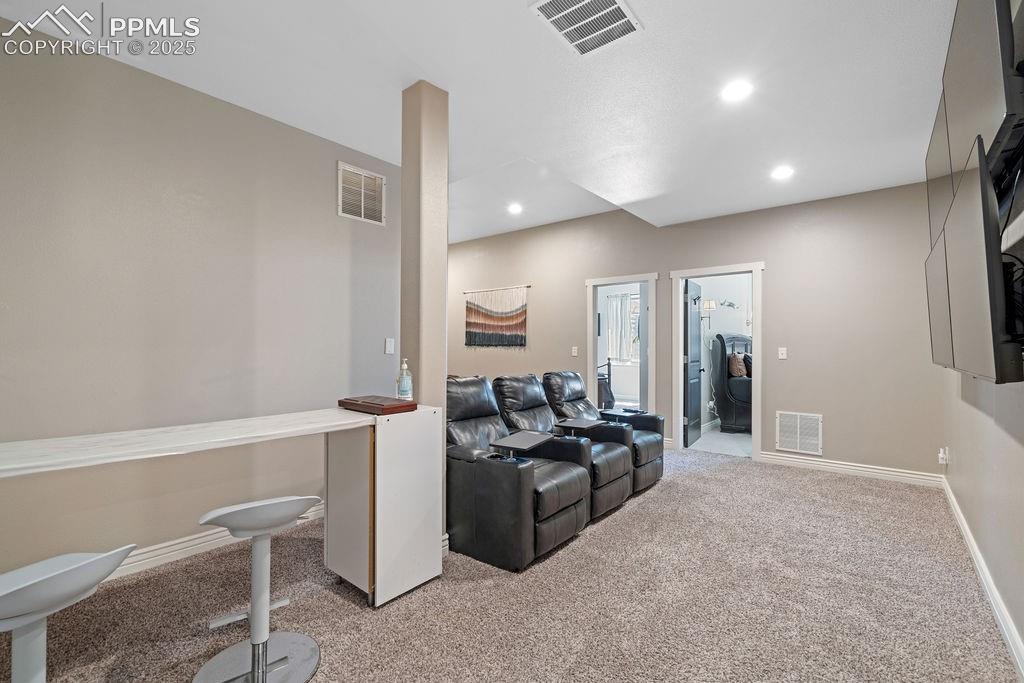 Image 30 of 50: Living area with light colored carpet and recessed lighting