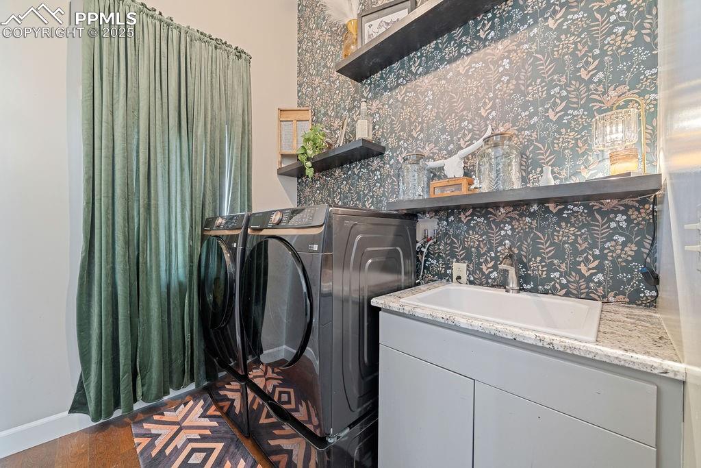 Image 31 of 50: Laundry area featuring separate washer and dryer and dark wood-type floorin