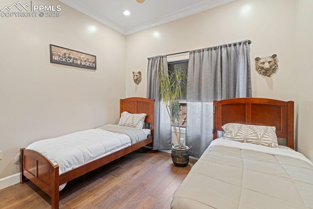 Image 36 of 50: Bedroom featuring ornamental molding, dark wood-style floors, and recessed 