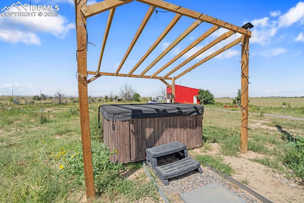 Image 48 of 50: View of yard with a pergola, a view of countryside, a hot tub, and a patio 