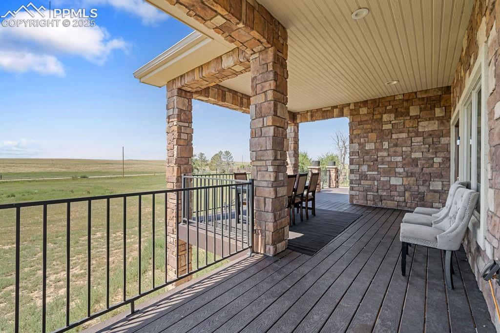 Image 7 of 50: Deck featuring outdoor dining area and a yard