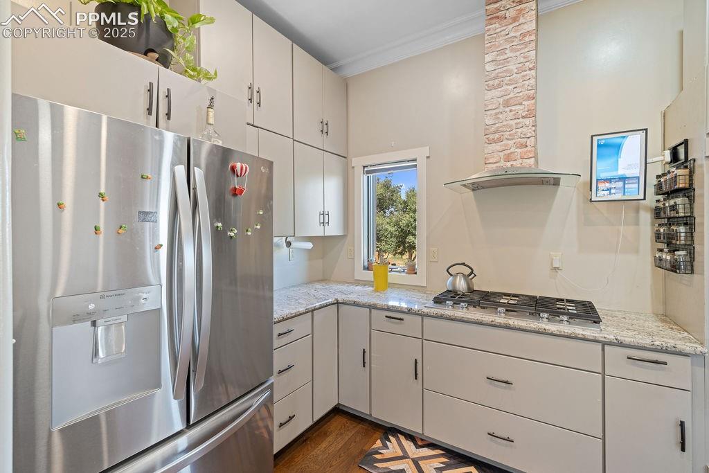 Image 8 of 50: Kitchen with appliances with stainless steel finishes, wall chimney range h
