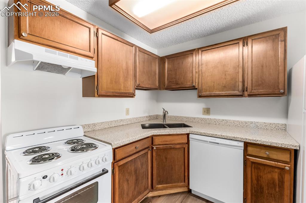 Image 10 of 25: Stone fireplace with wood mantel creates a cozy centerpiece in the living r