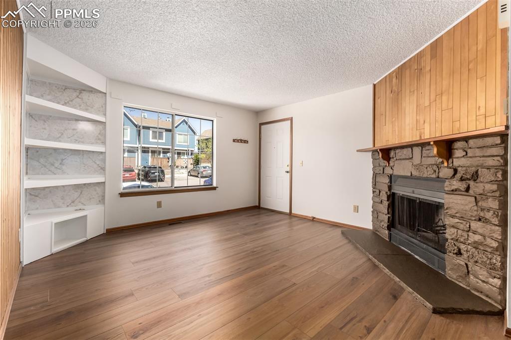 Image 3 of 25: *VIRTUALLY STAGED* Bright living room with large window and inviting firepl