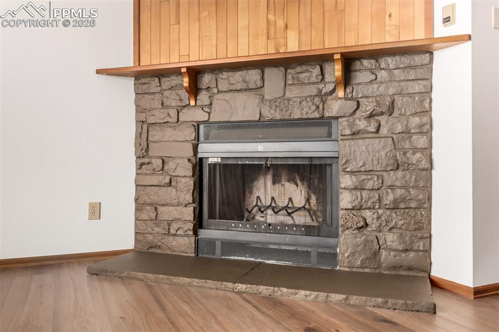 Image 7 of 25: Spacious living area with wood-style flooring and built-in shelving.