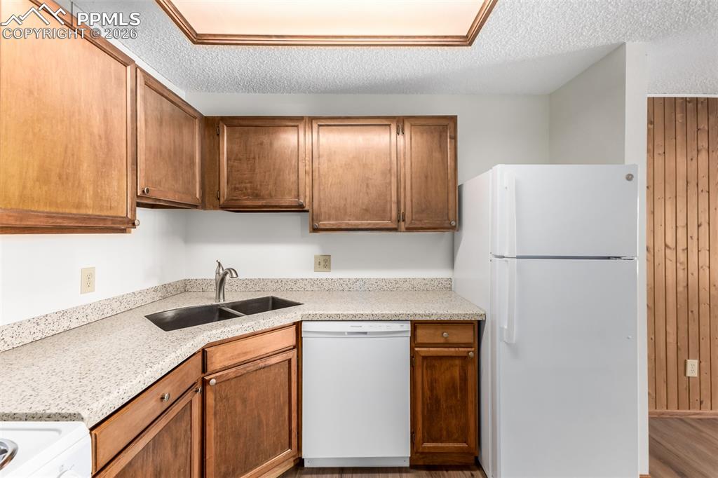 Image 9 of 25: Open-concept living space featuring a cozy stone fireplace and natural flow