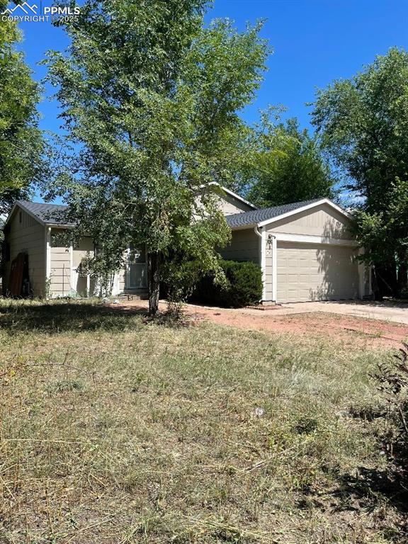 Caption: View of front of property with a garage and a front lawn