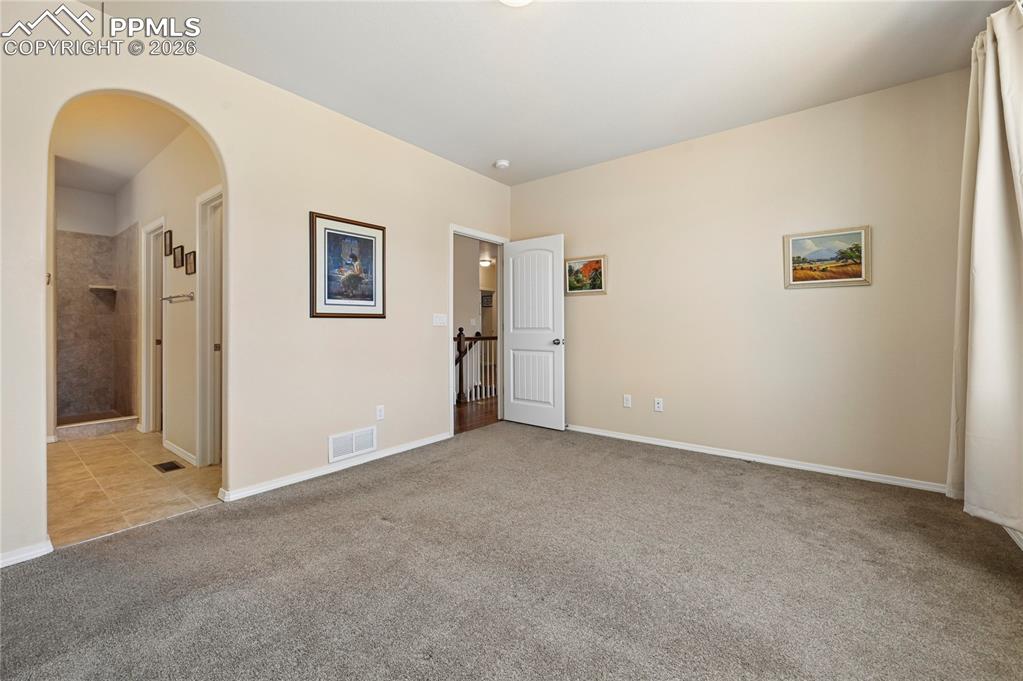 Image 12 of 37: Main level master bedroom has a marvelous en-suite bath & walk-in closet