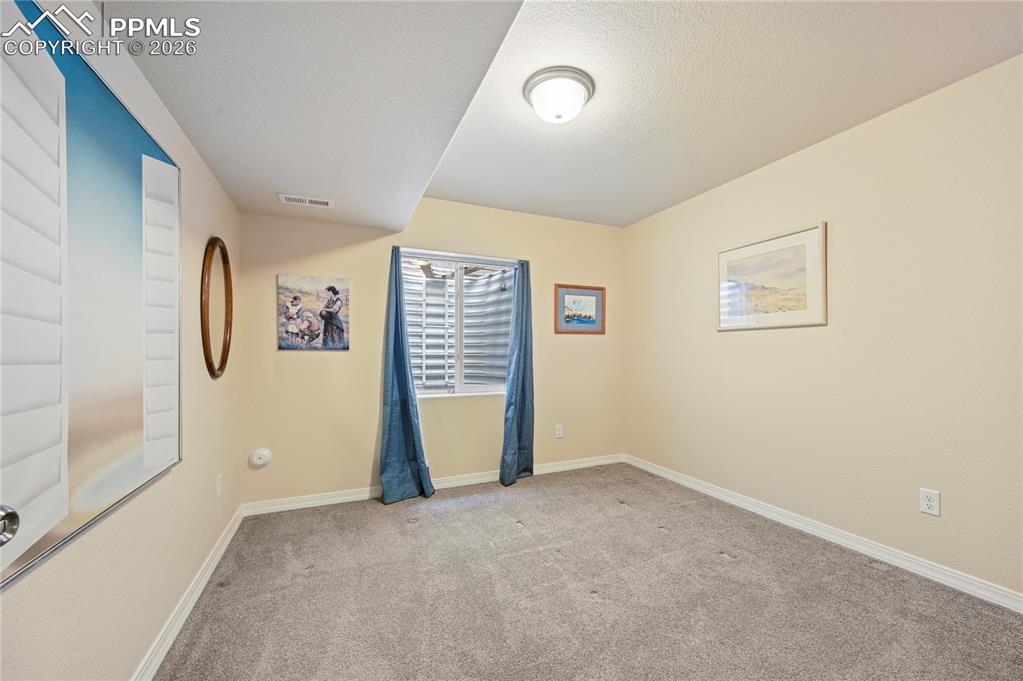 Image 22 of 37: Bedroom #3 of 4 is downstairs just across the hallway from a full bathroom.