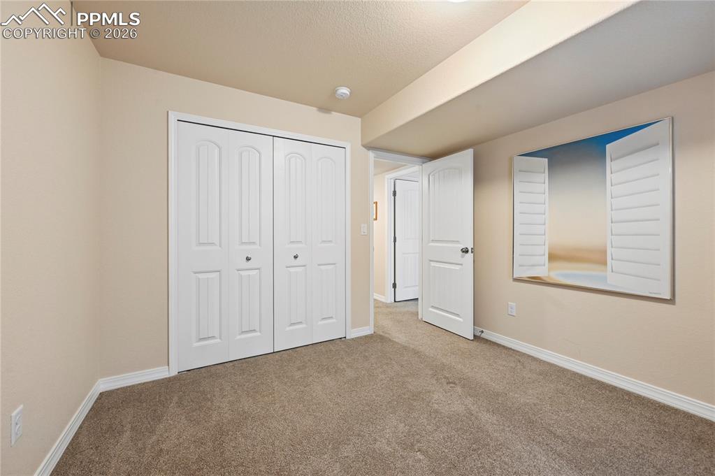 Image 23 of 37: The opposite view of bedroom #3 of 4 shows a good sized closet and warm, ea