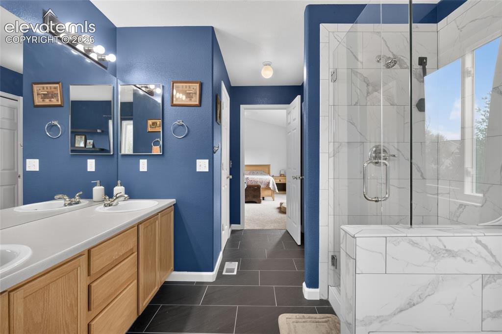 Image 12 of 30: Walk-in tile shower and double vanity