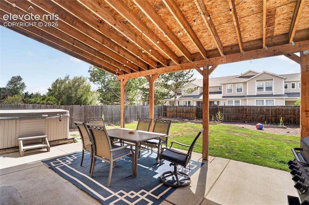 Image 19 of 30: Covered patio with hot tub