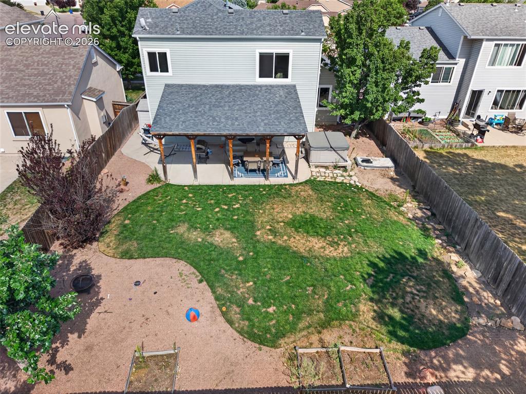 Image 23 of 30: Aerial of covered patio and backyard