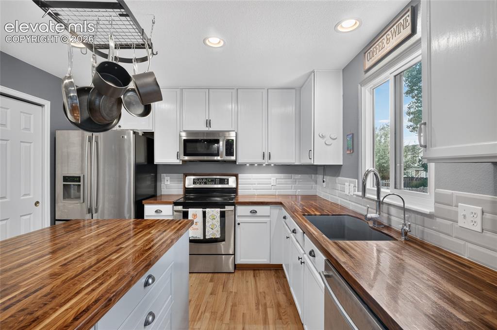 Image 8 of 30: Butcher block counters and subway tile